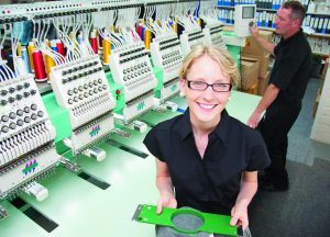 Worker examining fabric in factory