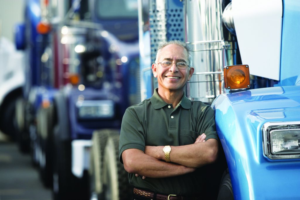 Middle aged man smiling beside his truck